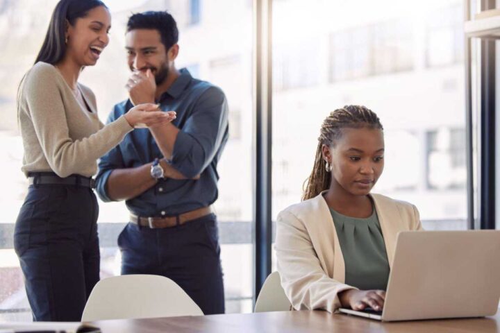 Shot of two businesspeople gossiping about a coworker at work