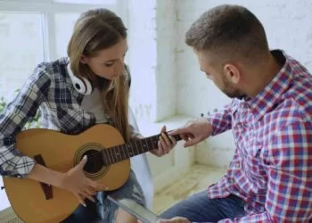 A woman learning to play the guitar