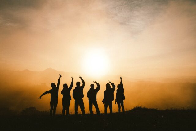 A silhouette of a group of friends at sunset used as cover picture for post named 7 impressive tips to make people like you, get more friends and how to make people like you