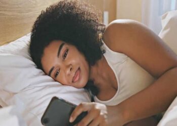 A beautiful woman smiling while reading from her phone