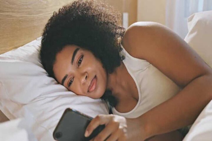 A beautiful woman smiling while reading from her phone