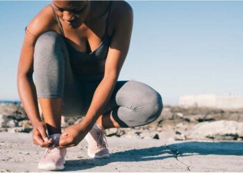 Beautiful young woman tying her shoes before going for a run