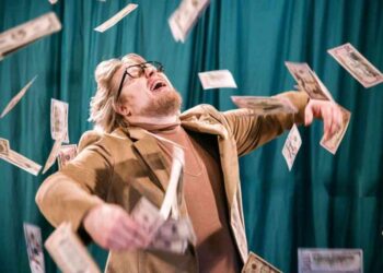 money is not everything; man celebrating in money