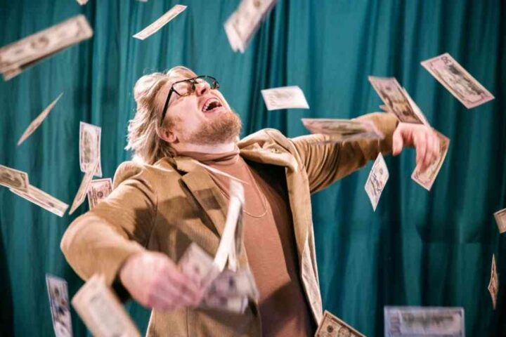 money is not everything; man celebrating in money